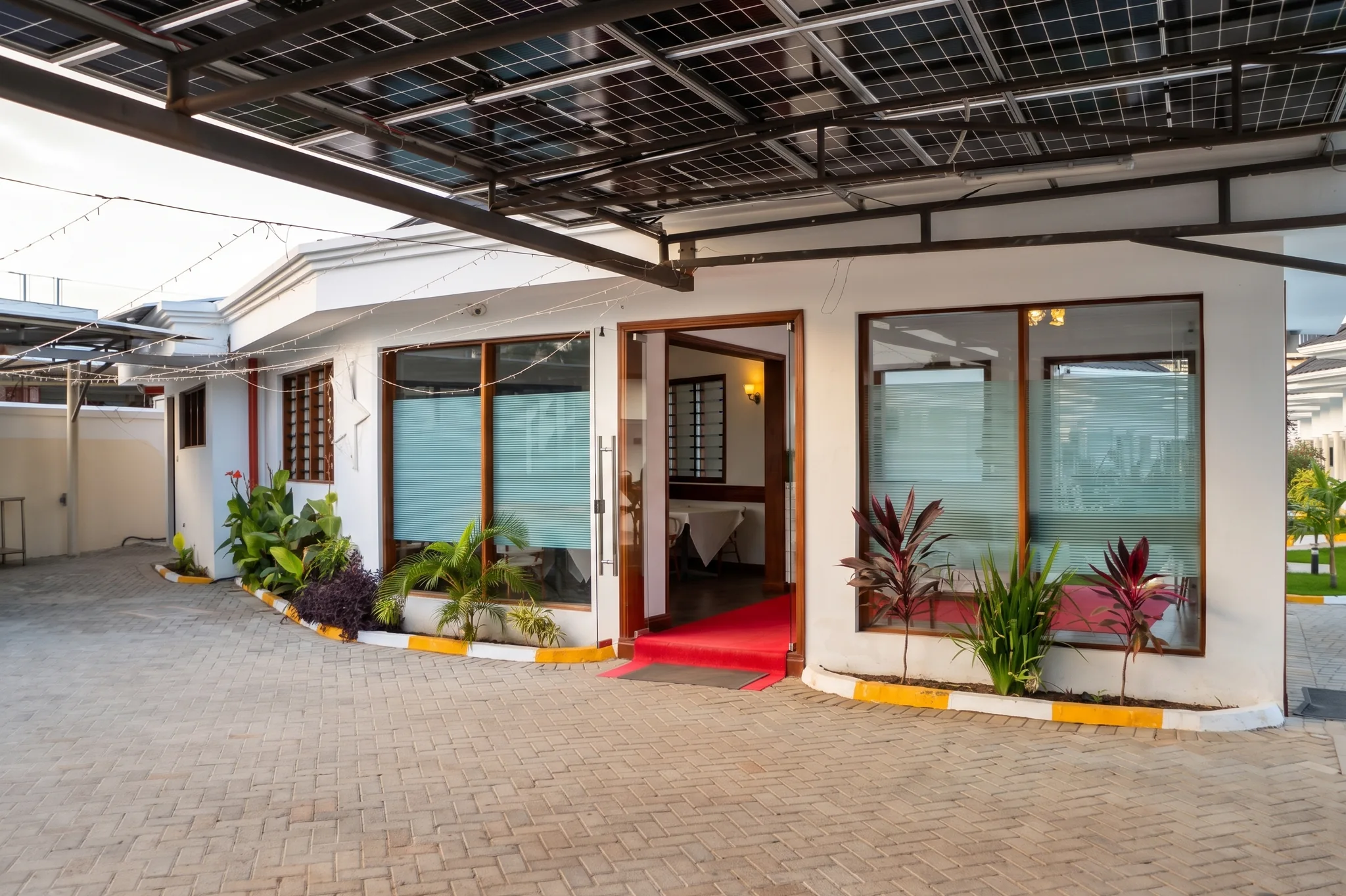 Resort clubhouse exterior view with solar parking canopy and landscaped grounds at Diani Darling