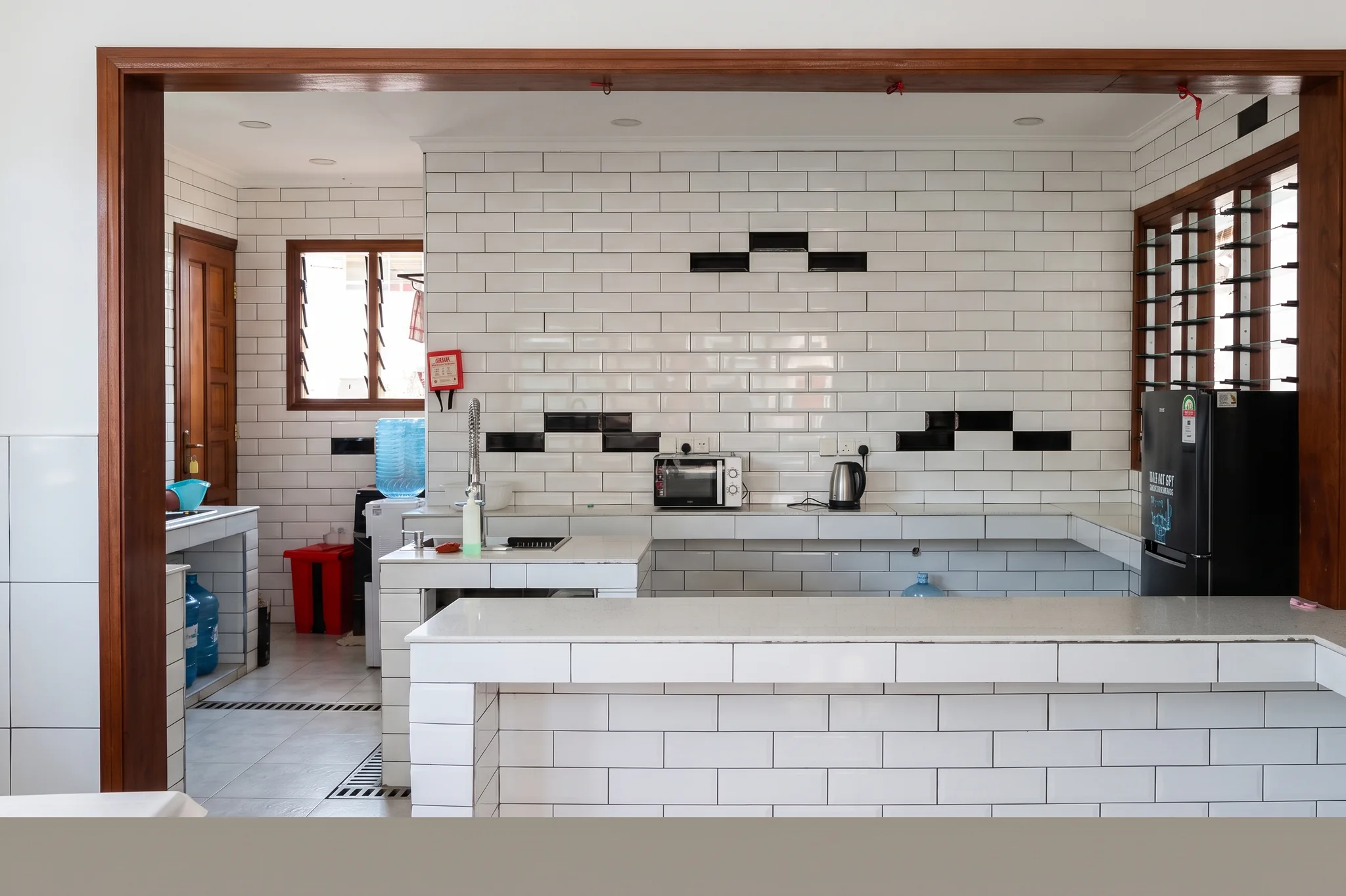 Spacious communal chef kitchen with commercial prep counters, stainless steel sinks, and appliances at Diani Darling