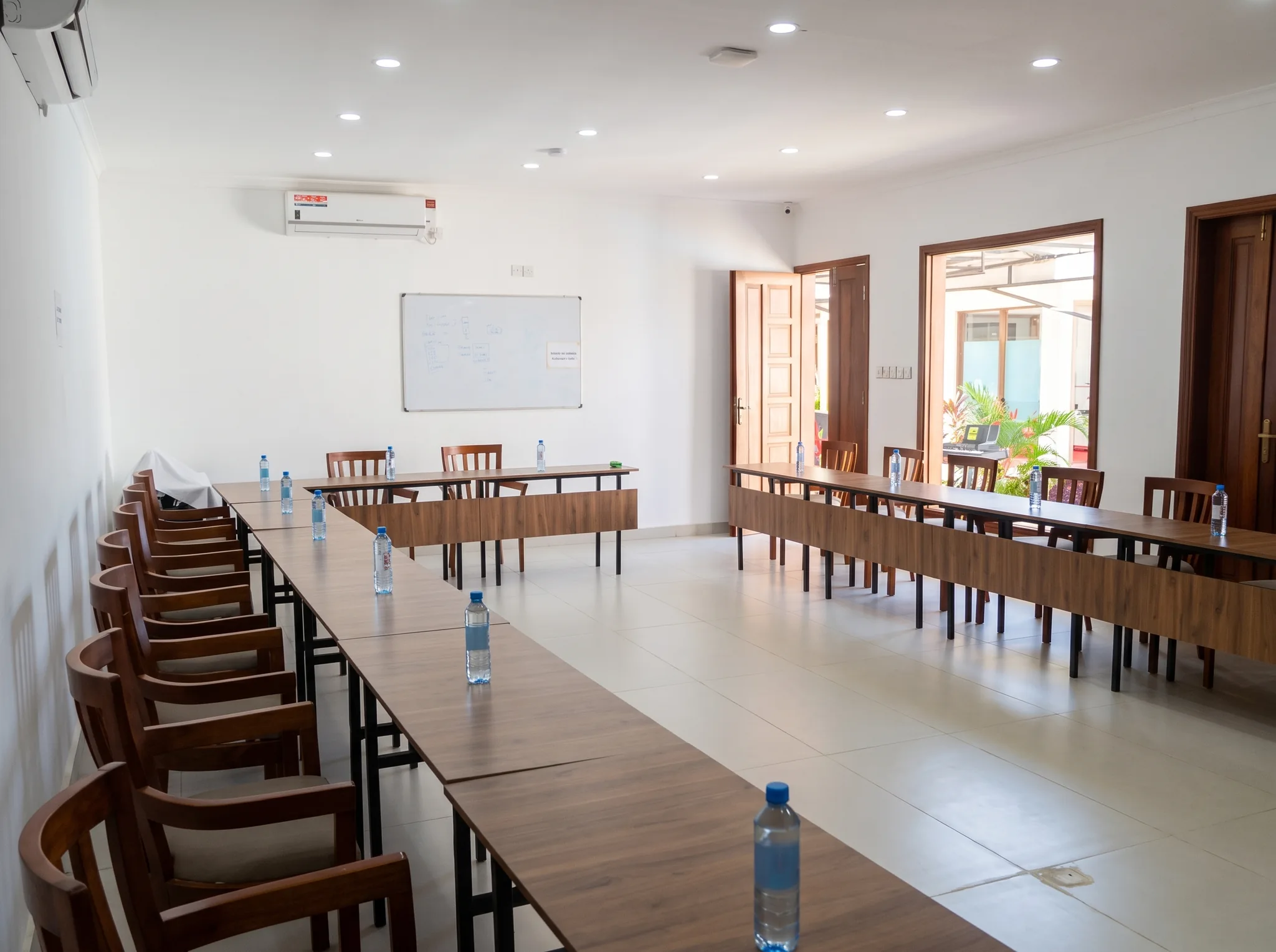 Modern air-conditioned conference hall and meeting facility setup with U-shaped executive tables at Diani Darling Cottages