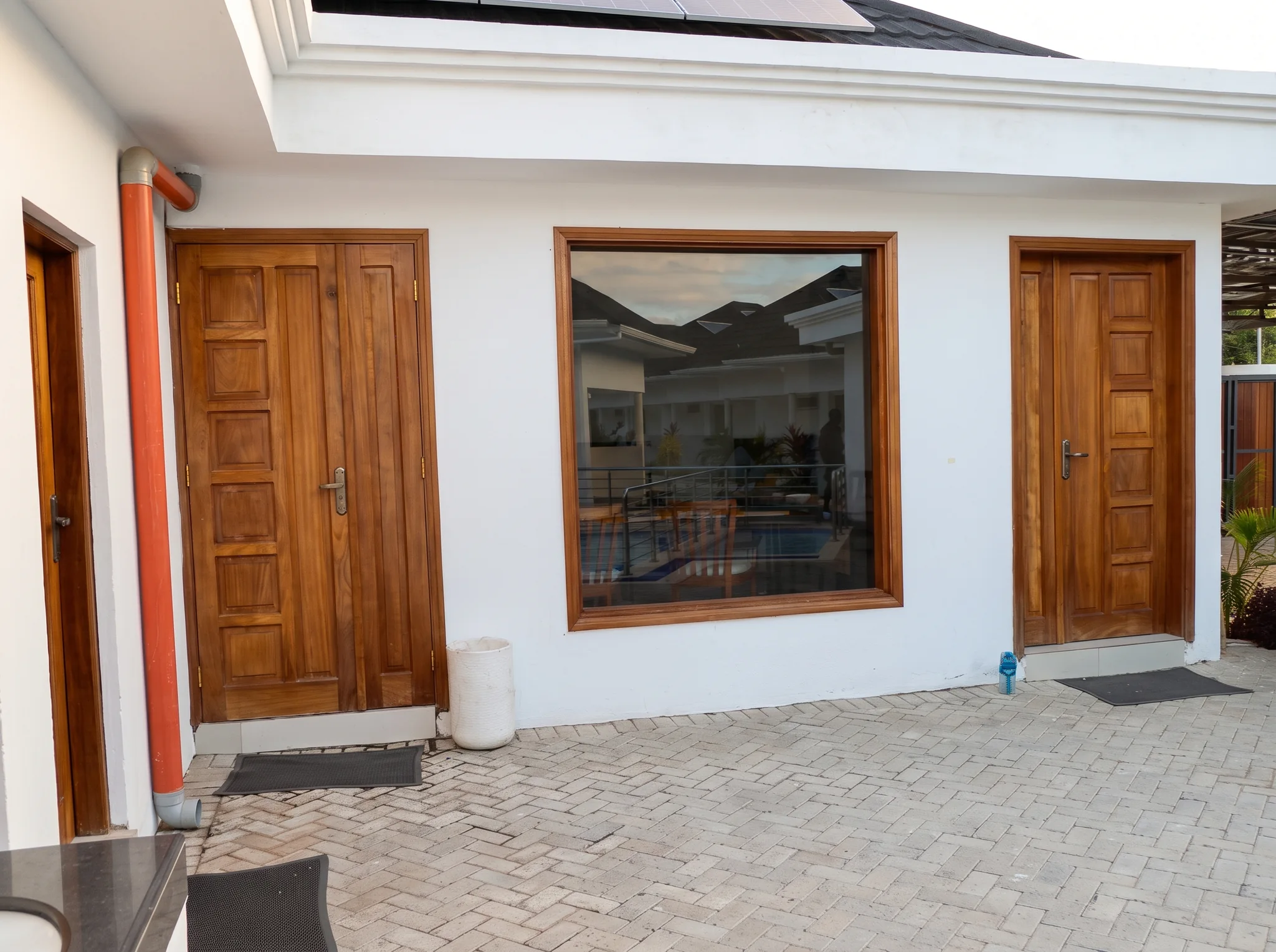 Exterior view of boutique cottage villa facade featuring polished mahogany doors and private patio