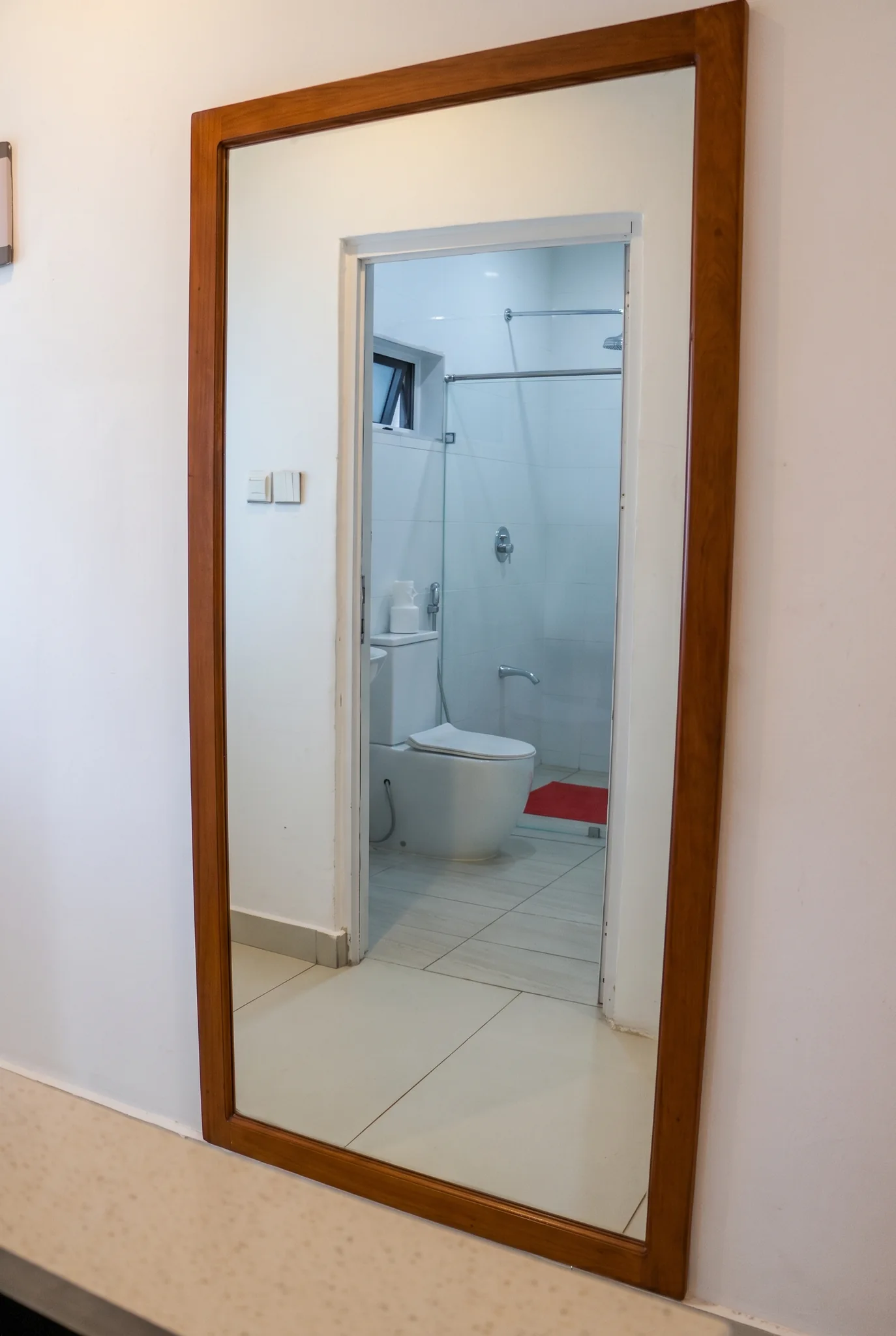 Deluxe studio interior reflection showcasing hardwood wardrobe, vanity mirror and modern bathroom