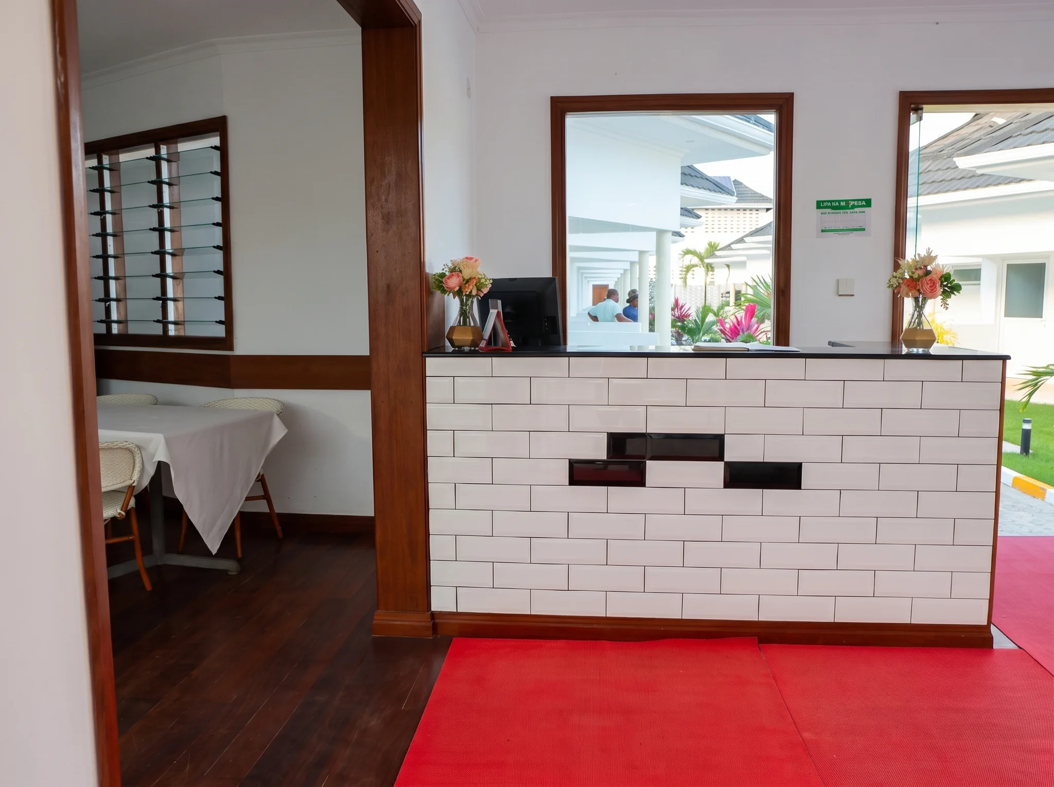 Welcoming reception lobby and guest lounge with polished front desk and dining seating at Diani Darling Cottages