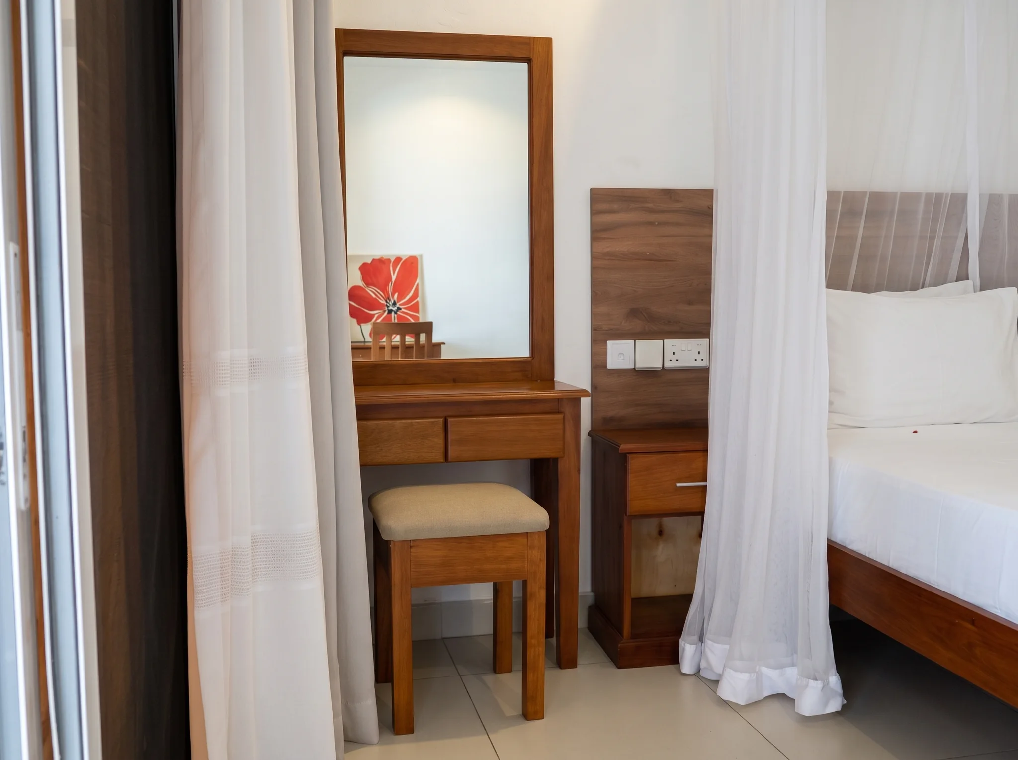 Studio bedroom dressing vanity table with mirror, stool and bedside electrical charging points at Diani Darling