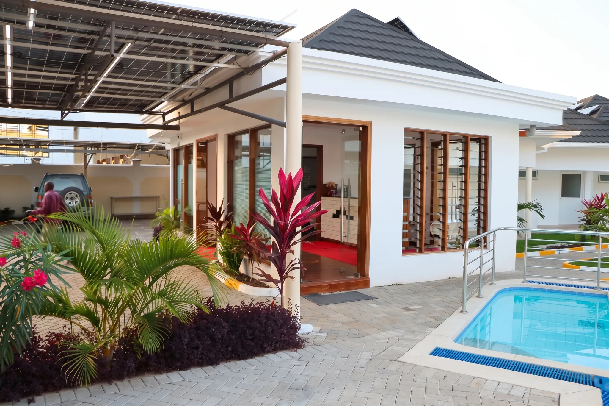Sparkling outdoor swimming pool with stainless steel railing and tropical landscaping at Diani Darling Cottages