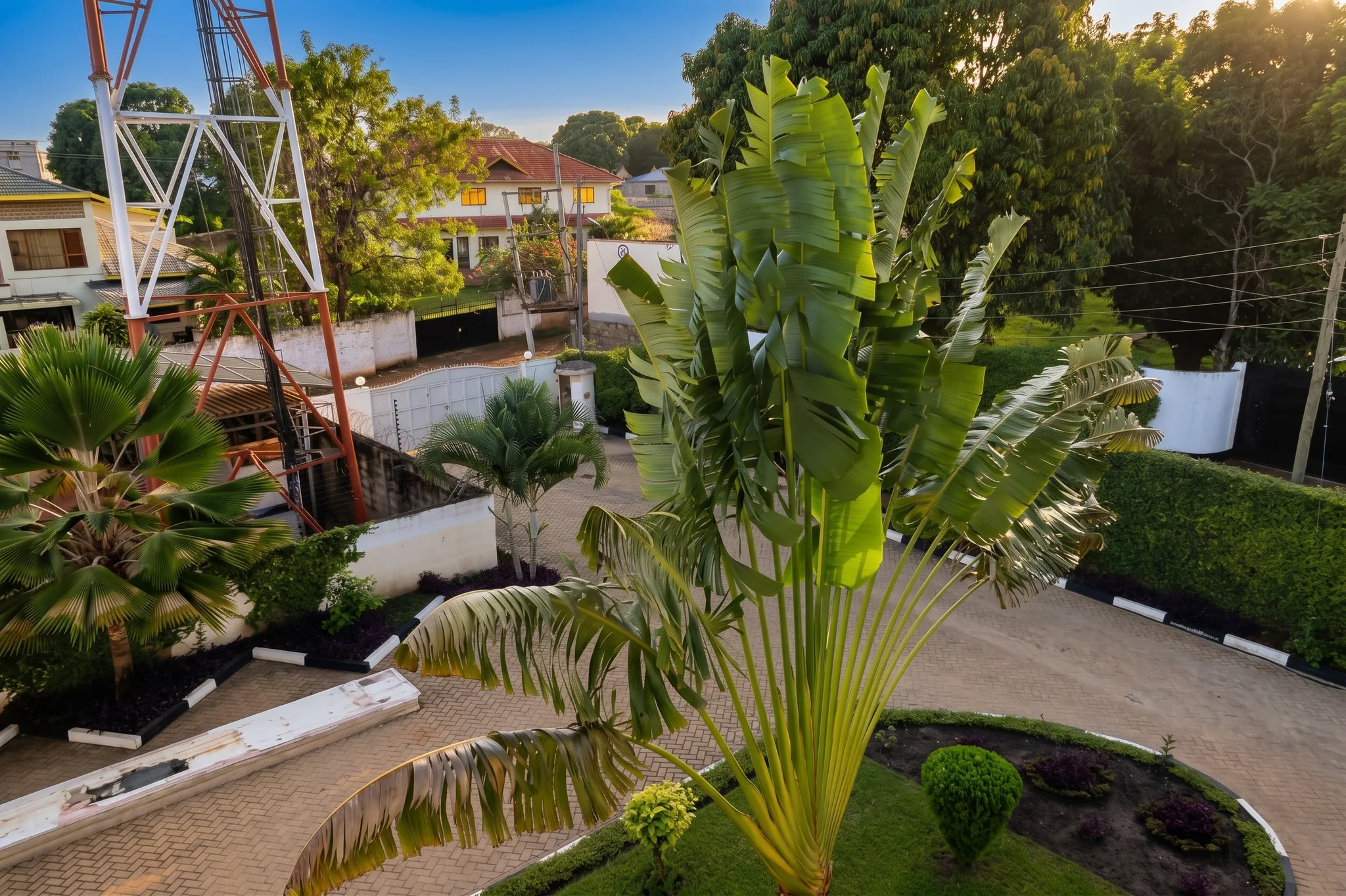 Lush tropical compound gardens and paved walkway at Tower Cottages Ukunda